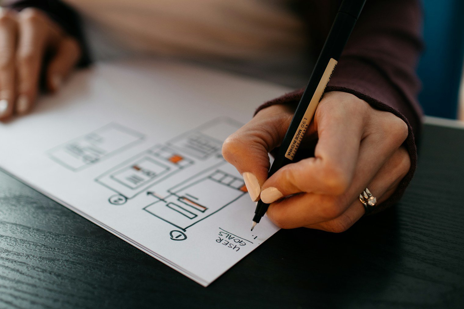 Hand sketching a mobile app wireframe on paper